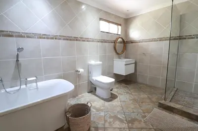 a bathroom with a toilet and a tub and a sink at 7 At Brainline in Pretoria