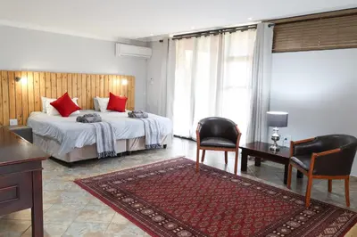 a bedroom with a bed and a desk and chairs at 7 At Brainline in Pretoria
