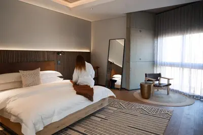 a woman sitting on a bed in a bedroom at Askara Haus in Pretoria