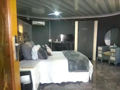 a bedroom with a large white bed with pillows at BEULAH GROUP BnB in Malamulele
