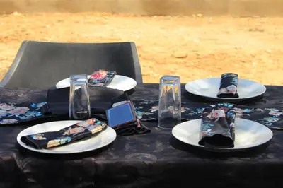 a table with plates and glasses with ties on them at BEULAH GROUP BnB in Malamulele