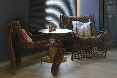two wicker chairs and a table in a room at BEULAH GROUP BnB in Malamulele