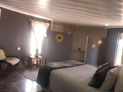 a bedroom with a large bed and a window at BEULAH GROUP BnB in Malamulele