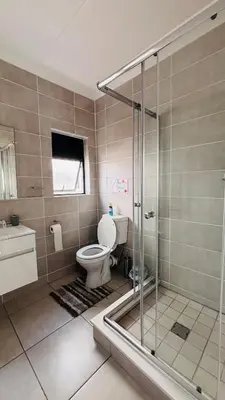 a bathroom with a toilet and a glass shower at The Blyde in Pretoria