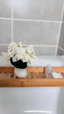 a vase with white flowers sitting on a shelf at The Blyde in Pretoria