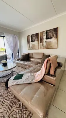 a large couch in a living room with a couch and a table at The Blyde in Pretoria