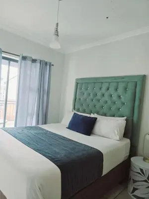 a bedroom with a large bed with a blue headboard at The Blyde in Pretoria