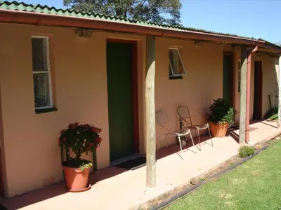 a porch of a house with chairs and plants at Kaapsche Draai in Kaapsehoop