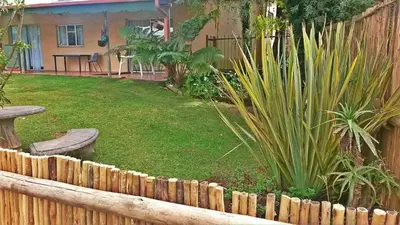 a backyard with a fence and a yard with plants at Kaapsche Draai in Kaapsehoop