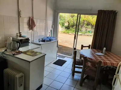 a kitchen with a table and a kitchen with a table and a tableablish at Kaapsche Draai in Kaapsehoop