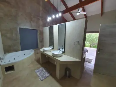a bathroom with a tub and a sink and a bath tub at Lionsview Private Lodge - 4 Lions in Marloth Park