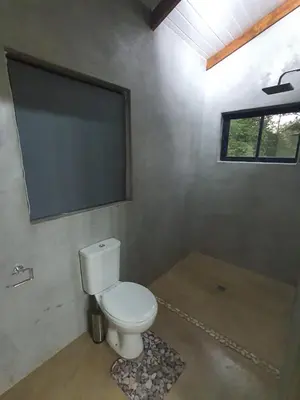 a bathroom with a white toilet and a window at Lionsview Private Lodge - 4 Lions in Marloth Park