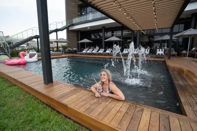 a woman sitting in front of a swimming pool at The Capital Mbombela in Nelspruit