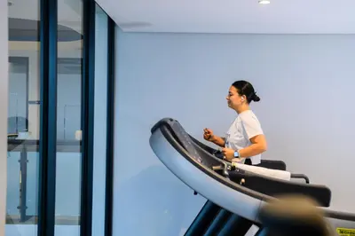 a woman riding on a treadmill in a gym at The Capital Mbombela in Nelspruit