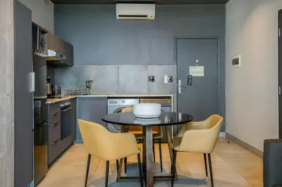a kitchen with a table and chairs in it at The Capital Mbombela in Nelspruit