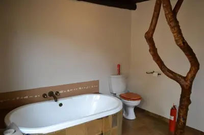 a bathroom with a white tub and a toilet at 86 Zebula 10 Sleeper Lodge in Mabula