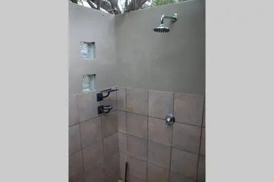 a bathroom with a shower with a shower head at 86 Zebula 10 Sleeper Lodge in Mabula