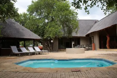 a swimming pool in front of a house at 86 Zebula 10 Sleeper Lodge in Mabula