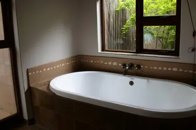 a bath tub in a bathroom with a window at 86 Zebula 10 Sleeper Lodge in Mabula