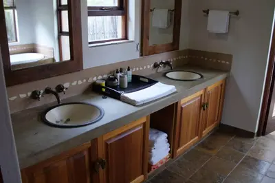 a bathroom with two sinks and two mirrors at 86 Zebula 10 Sleeper Lodge in Mabula