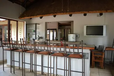 a group of chairs sitting at a bar at 86 Zebula 10 Sleeper Lodge in Mabula