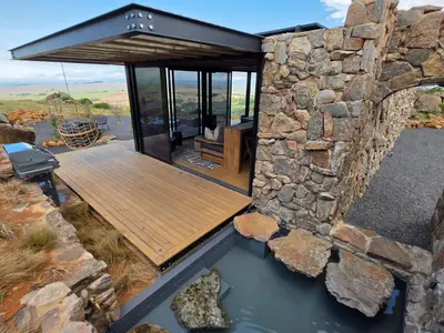 a stone walled house with a pool of water at Eagle View on Beumont in Dullstroom