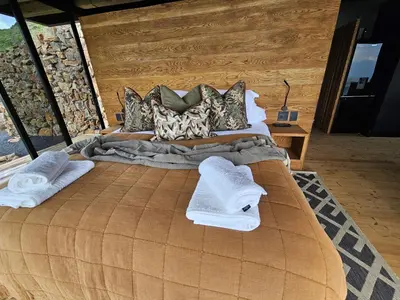 a bedroom with a large bed with towels on it at Eagle View on Beumont in Dullstroom