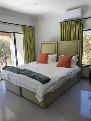 a bedroom with a large bed with red pillows at Via Lactea in Mmafefe