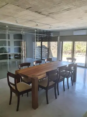 a large wooden table and chairs in a room at Via Lactea in Mmafefe