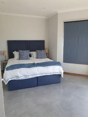 a bedroom with a large blue bed in a room at Via Lactea in Mmafefe