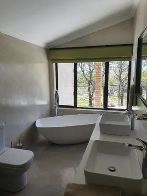 a bathroom with a tub and a toilet and a sink at Via Lactea in Mmafefe