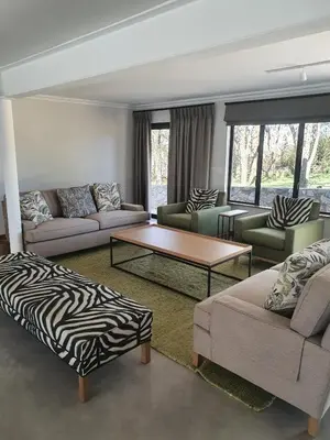 a living room with two couches and a zebra print coffee table at Via Lactea in Mmafefe