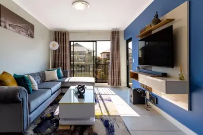 a living room with a couch and a tv at #AlimamaSpaces: The Hakings Luxury Place in Midrand