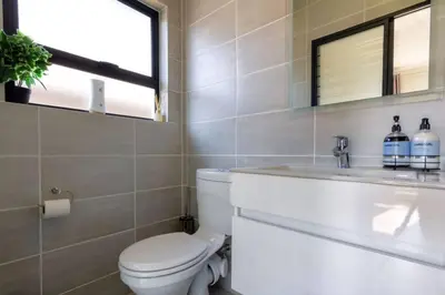 a bathroom with a toilet and a sink at #AlimamaSpaces: The Hakings Luxury Place in Midrand