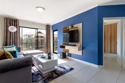 a living room with a blue wall at #AlimamaSpaces: The Hakings Luxury Place in Midrand