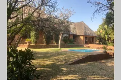 a house with a swimming pool in the yard at Thala Thala Private Villa in the bush-veld in Cullinan