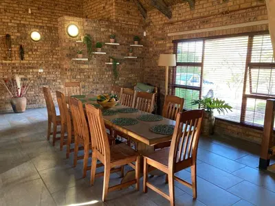 a dining room with a table and chairs at Thala Thala Private Villa in the bush-veld in Cullinan