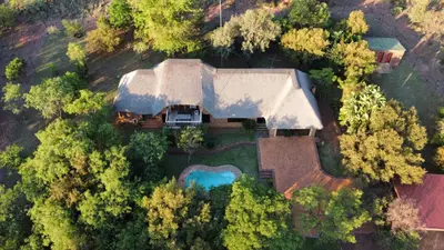 an aerial view of a house with a swimming pool at Thala Thala Private Villa in the bush-veld in Cullinan