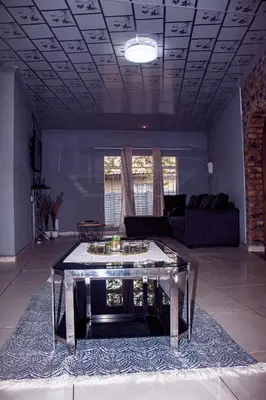 a living room with a table and a couch at Warmbaths Thai Spa and Guest House in Bela-Bela