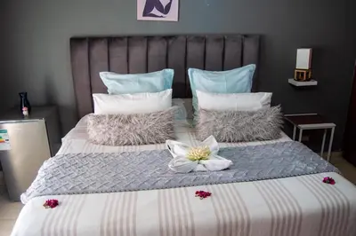 a large bed with a flower on top of it at Warmbaths Thai Spa and Guest House in Bela-Bela