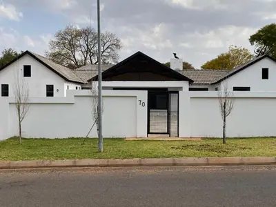 a white house with a black roof at The King's Court Guest Manor in Bela-Bela
