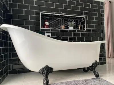 a white bath tub in a bathroom with a fireplace at The King's Court Guest Manor in Bela-Bela