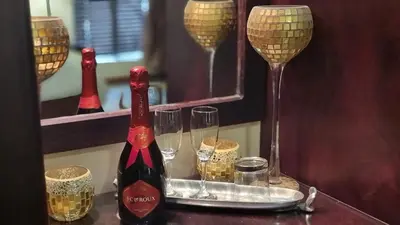 a bottle of wine and glasses on a table at Zoete Rust Boutique Hotel in Lephalale