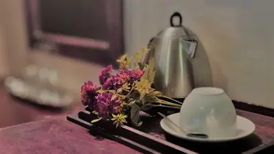 a table with a tea pot and a bouquet of flowers at Zoete Rust Boutique Hotel in Lephalale