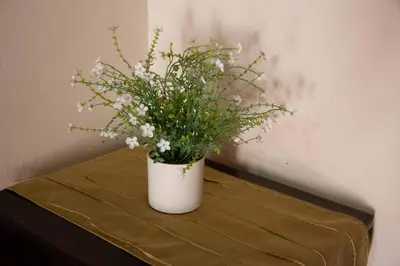 a white vase with white flowers on a table at Zoete Rust Boutique Hotel in Lephalale