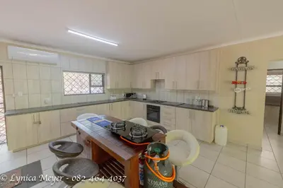 a large kitchen with a table and chairs in it at Mamba Bush House in Marloth Park