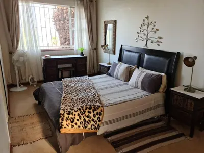 a bedroom with a bed with a leopard blanket on it at Kosmos View Luxury Apartments in Hartbeespoort