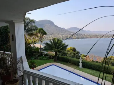 a balcony with a swimming pool and a view of the water at Kosmos View Luxury Apartments in Hartbeespoort