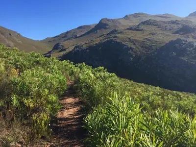 a dirt trail on a hill with mountains in the background at Kosmos View Luxury Apartments in Hartbeespoort