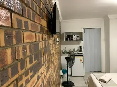 a brick wall in a room with a kitchen at GTI Guest House in Pretoria